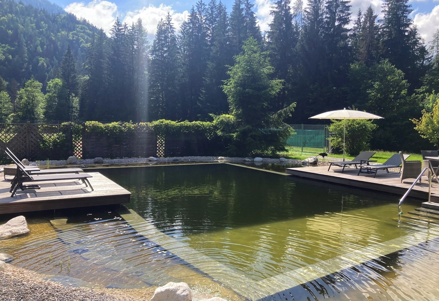 Entspannen Sie in der ruhigen Gartenanlage mit dem idyllischen Naturbadeteich.