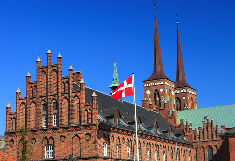 Majestätische Türme, rote Backsteinfassaden und jahrhundertealte Geschichte machen die Kathedrale von Roskilde zu einem eindrucksvollen Wahrzeichen Dänemarks.
