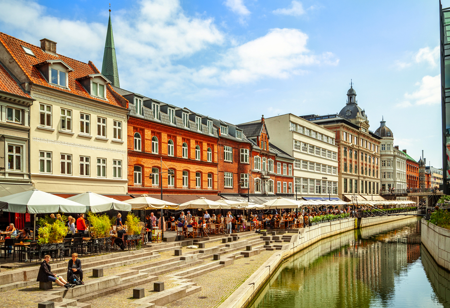 Wenn sich die Sonne im Wasser spiegelt und die Straßencafés zum Verweilen einladen, zeigt Aarhus an der Åboulevarden seine lebendige Seite.