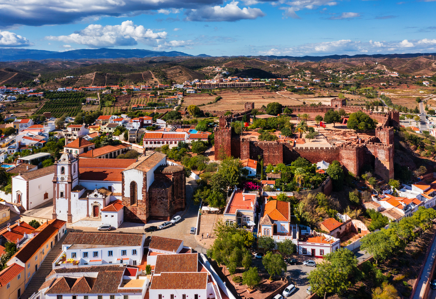 Über den Dächern von Silves entfaltet sich ein beeindruckendes Panorama aus historischer Burg, Kathedrale und sanften Hügeln.