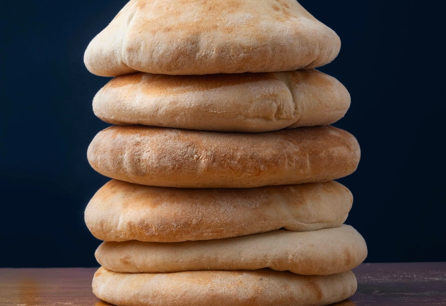 Frisches Tabouna-Brot wird traditionell im Lehmofen gebacken und überzeugt mit knuspriger Kruste und weichem Inneren.