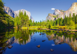 Im Yosemite-Nationalpark in Kalifornien spiegeln sich majestätische Granitfelsen und grüne Wälder im glasklaren Wasser.