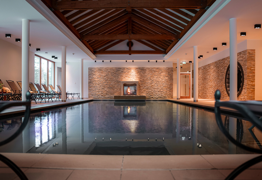 Genießen Sie eine Auszeit im Hallenbad mit Blick auf das Kaminfeuer.