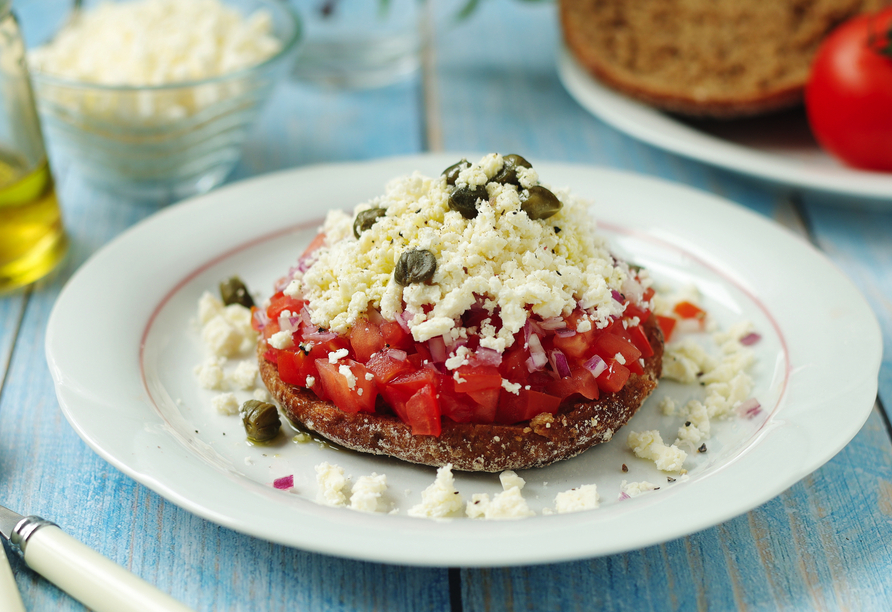 Probieren Sie einen Klassiker der kretischen Küche: Dakos mit fruchtigen Tomaten, würzigem Käse und einem Hauch Oregano, einfach und köstlich.