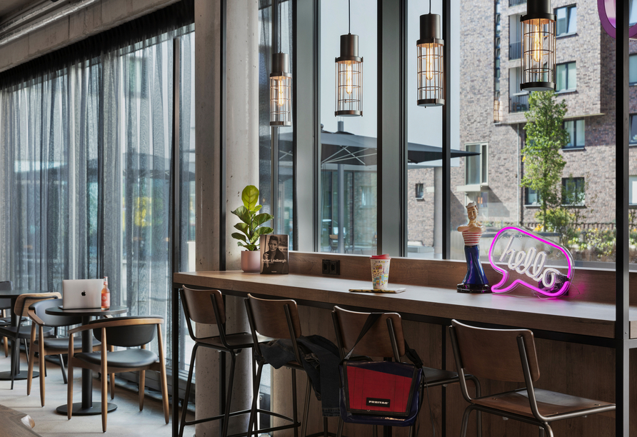 Nehmen Sie Platz am Fenster und genießen Sie einen Moment Ruhe bei urbanem Ausblick.