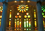 Die Buntglasfenster im Innenraum der Sagrada Familia sind in den Farben Rot, Blau, Grün und Ocker gestaltet.
