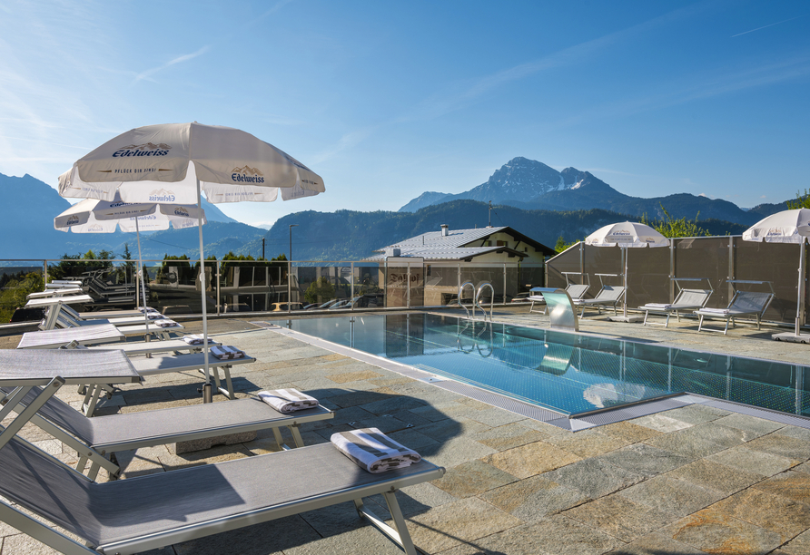 Genießen Sie die sonnige Poolterrasse mit herrlichem Panoramablick auf die beeindruckende Tiroler Bergwelt.