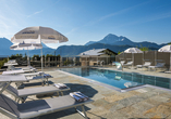 Genießen Sie die sonnige Poolterrasse mit herrlichem Panoramablick auf die beeindruckende Tiroler Bergwelt.