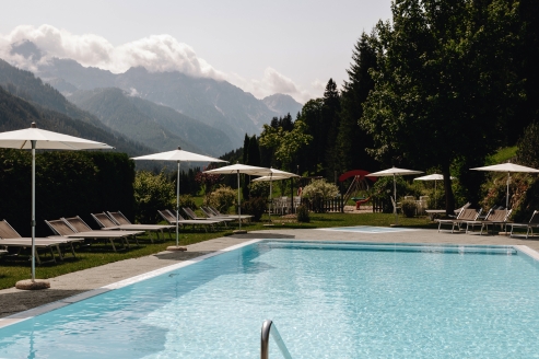 Erholen Sie sich von einem ereignisreichen Tag am Außenpool des Hotels und lassen Sie den Blick über das Bergpanorama schweifen.