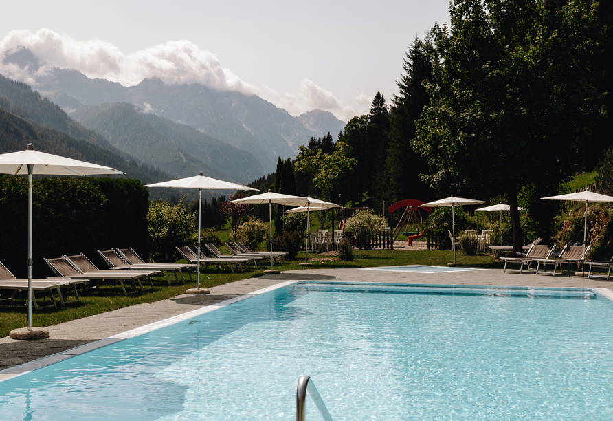 Erholen Sie sich von einem ereignisreichen Tag am Außenpool des Hotels und lassen Sie den Blick über das Bergpanorama schweifen.