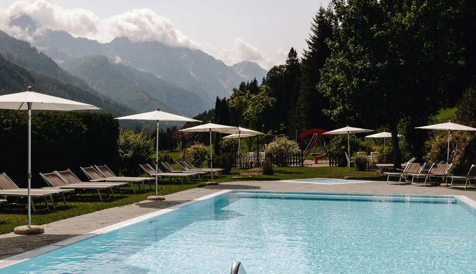 Erholen Sie sich von einem ereignisreichen Tag am Außenpool des Hotels und lassen Sie den Blick über das Bergpanorama schweifen.