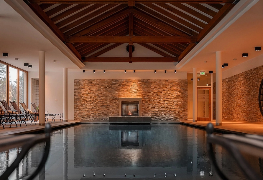 Genießen Sie eine Auszeit im Hallenbad mit Blick auf das Kaminfeuer.