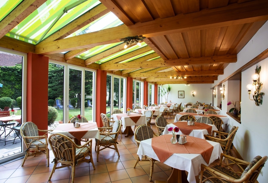 Der lichtdurchflutete Wintergarten lädt zu genussvollen Stunden in stilvollem Ambiente ein.