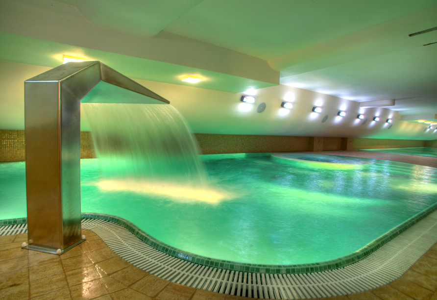 Das Hallenbad mit Wasserfall sorgt für erfrischende und entspannte Momente.