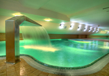 Das Hallenbad mit Wasserfall sorgt für erfrischende und entspannte Momente.