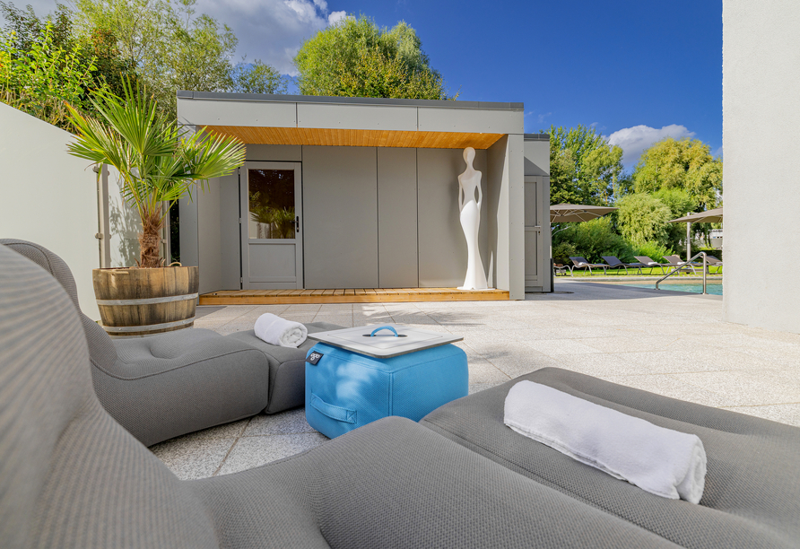 Entspannen Sie im Außenbereich des Hotels mit Pool, Außensauna und gemütlichen Liegeflächen.