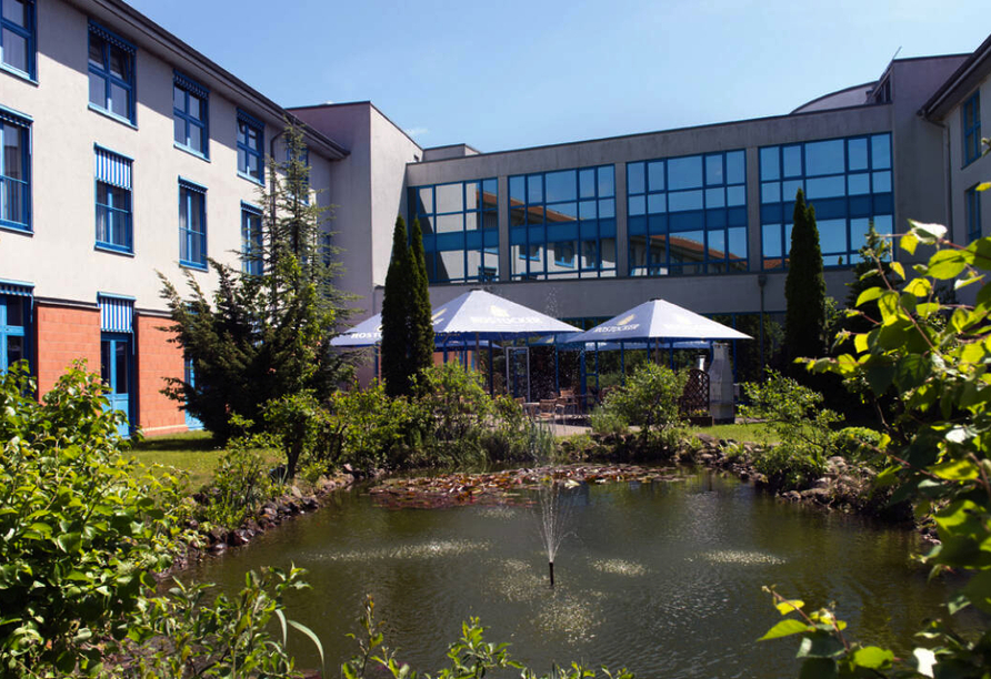 Das Hotel präsentiert sich idyllisch am hauseigenen Teich und fügt sich harmonisch in die grüne Umgebung ein.