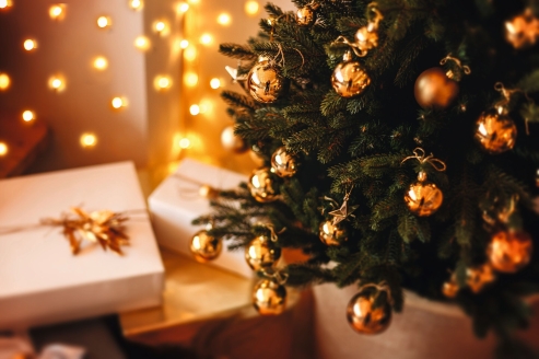 Ein festlich geschmückter Weihnachtsbaum mit liebevoll verpackten Geschenken.