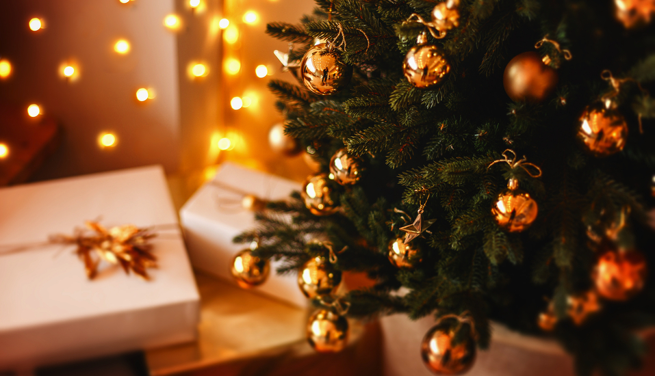 Ein festlich geschmückter Weihnachtsbaum mit liebevoll verpackten Geschenken.