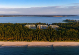Die Drohnenaufnahme zeigt die besondere Lage des Resorts: Nur rund 60 Meter trennen das Hotel von der Ostsee, während es von dichtem Küstenwald umgeben ist.