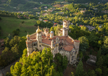 Bei einer Führung entdecken Sie die außergewöhnliche Rocchetta Mattei inmitten der grünen Landschaft des Apennins.
