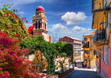 Farbenfrohe Häuser, üppige Blüten und historische Gassen prägen das mediterrane Flair von Korfu-Stadt.
