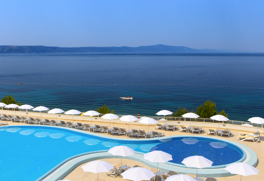 Türkisblaues Poolwasser und ein weiter Meerblick sorgen für echtes Urlaubsgefühl.