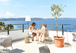 Lassen Sie auf der Terrasse des Hotel TUI BLUE Makarska den Blick über das glitzernde Meer schweifen. | KI bearbeitet