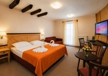 Beispielbild eines Doppelzimmers Deluxe mit Zustellbett | KI bearbeitet