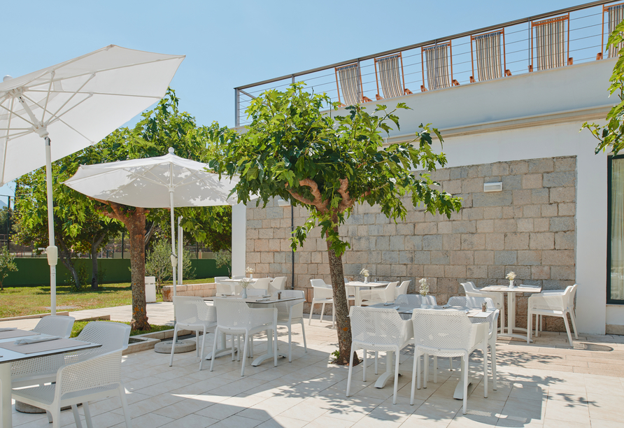 Die helle Terrasse mit ihren schattigen Sitzplätzen lädt zum Verweilen ein.