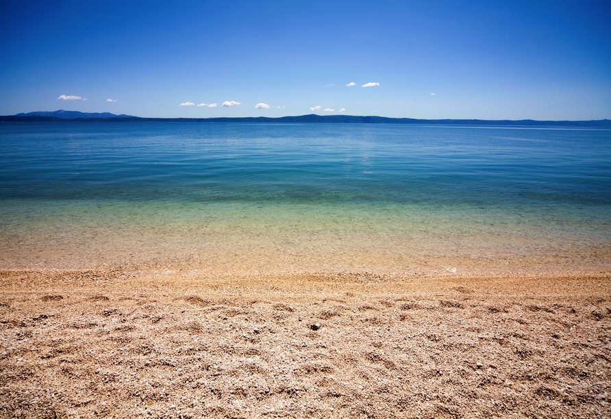 Kristallklares Wasser und ein herrlicher Kiesstrand laden zum Entspannen an der Adria ein.