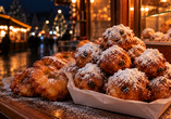 Probieren Sie zu Silvester traditionelle niederländische Oliebollen mit Puderzucker.