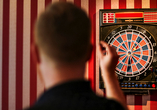 Spielen Sie eine Runde Dart.