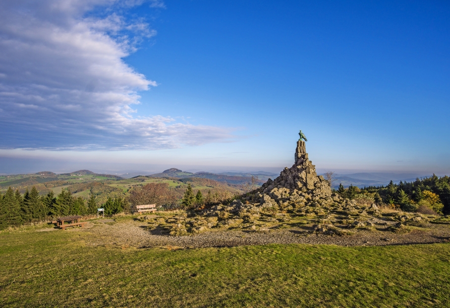 Betrachten Sie von der Wasserkuppe aus die weiten Wiesen und saftgrünen Wälder der Rhön.