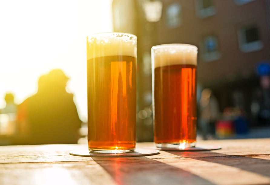 Probieren Sie unbedingt das typische Altbier in Düsseldorf, an der „längsten Theke der Welt“.