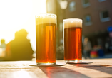 Probieren Sie unbedingt das typische Altbier in Düsseldorf, an der „längsten Theke der Welt“.