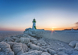 Leuchtturm in Sassnitz auf der Insel Rügen im Winter, umgeben von Eis und Schnee.
